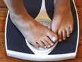 woman on scale unhappy with her weight