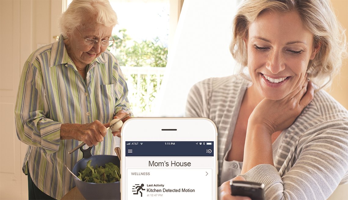 Adult daughter checks mobile phone for status of elderly mom