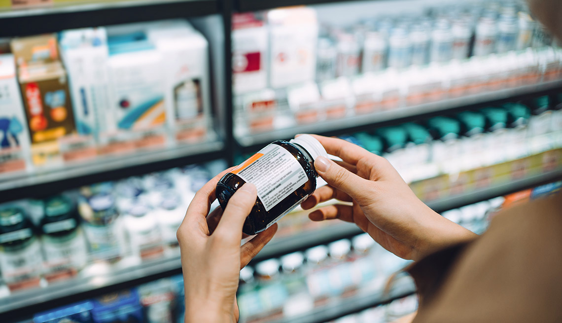 person looking at supplement bottle