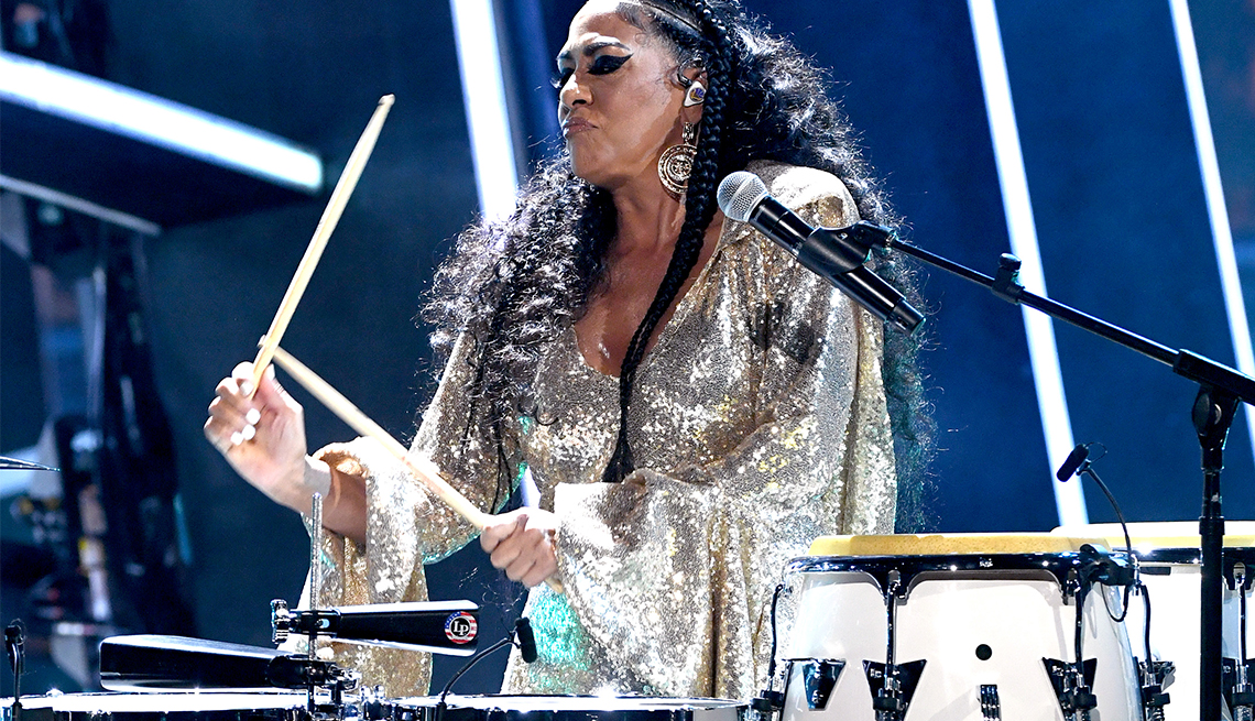 sheila e playing drums and wearing sparkly silver outfit