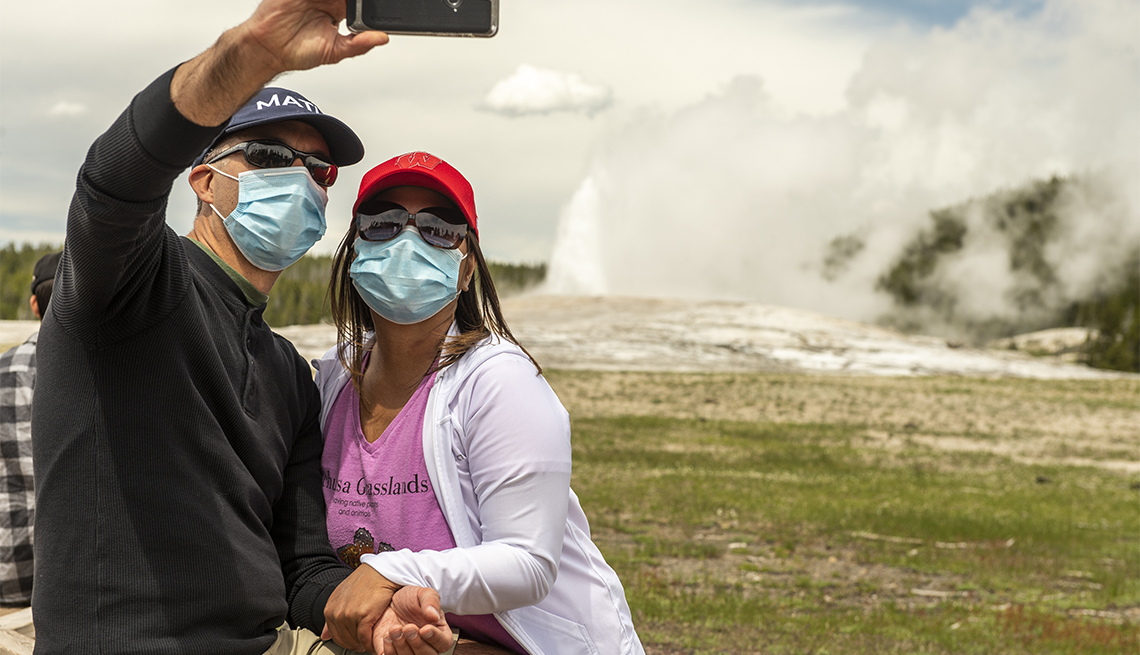 a couple takes a selfie as Old Faithful a couple takes a selfie as Old Faithful