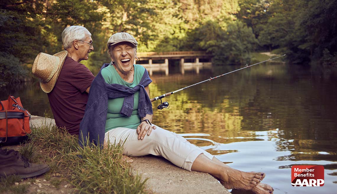a couple fishing near a lake and laughing