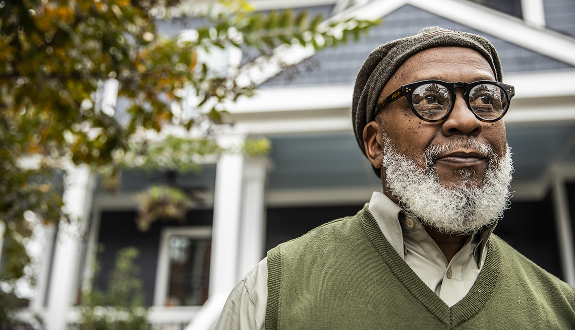 portrait of a man in front of his home