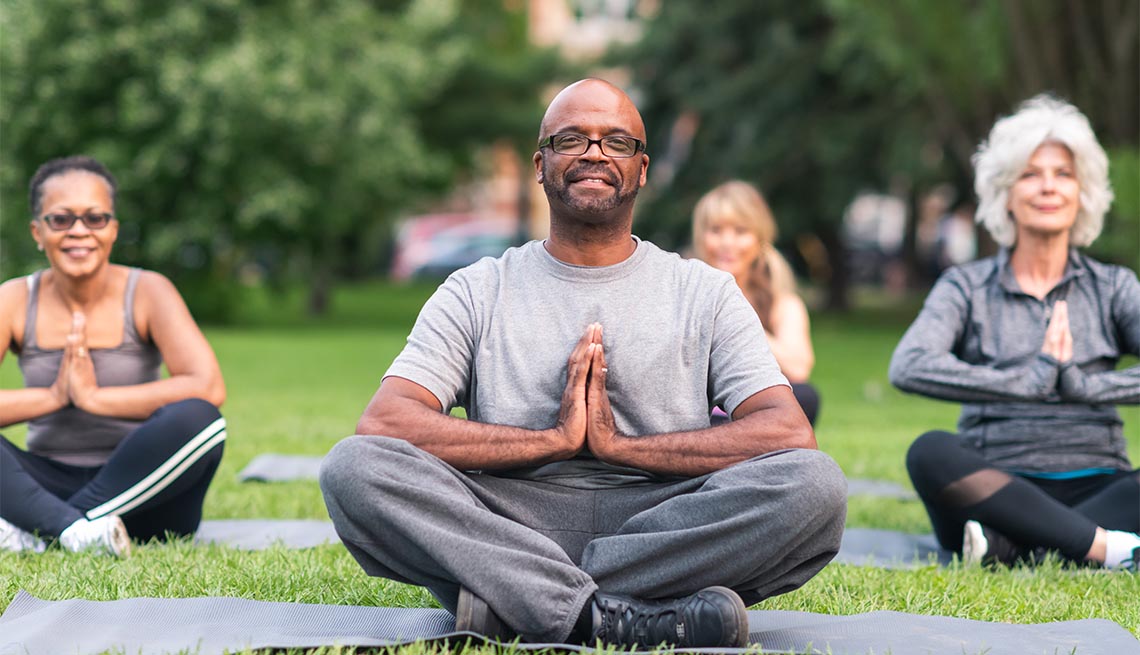 A multi-ethnic group of seniors attending a yoga class outdoors