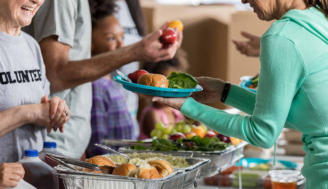 volunteers serves meals to older people in need