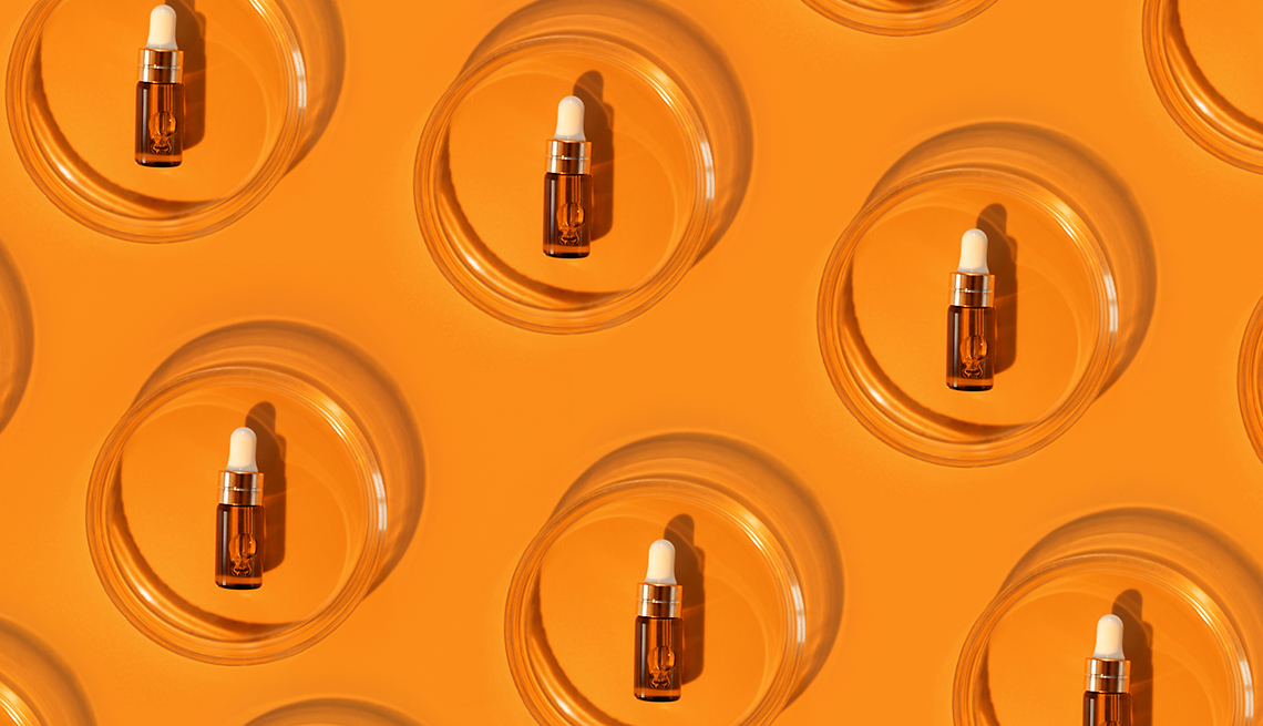 Vials of amber-colored laboratory serum vials arranged on an  orange background.