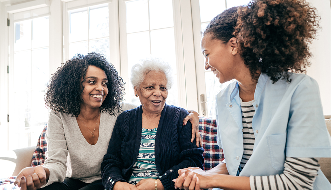Age-friendly Health 934843532 two younger women talking with older woman on a couch