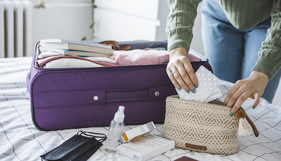a woman is packing her suitcase and putting her medicine in her carry on bag a woman is packing her suitcase and putting her medicine in her carry on bag