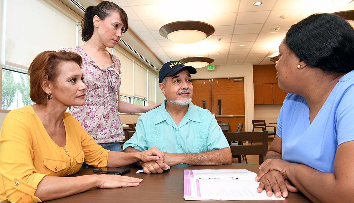 a group of people sitting around a table looking at paperwork