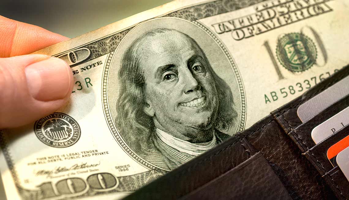 Billete de 100 dólares que una mano saca de una billetera - Quiz del coeficiente intelectual financiero Billete de 100 dólares que una mano saca de una billetera - Quiz del coeficiente intelectual financiero