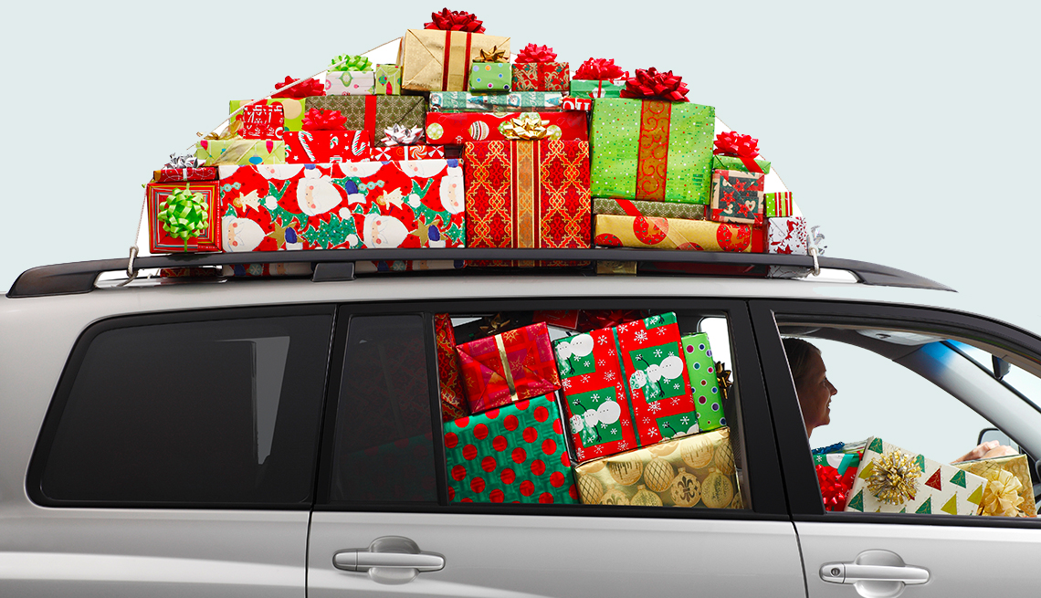 Una mujer conduciendo un todoterreno lleno de regalos de Navidad.