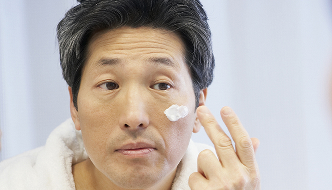 Hombre colocándose crema en la cara