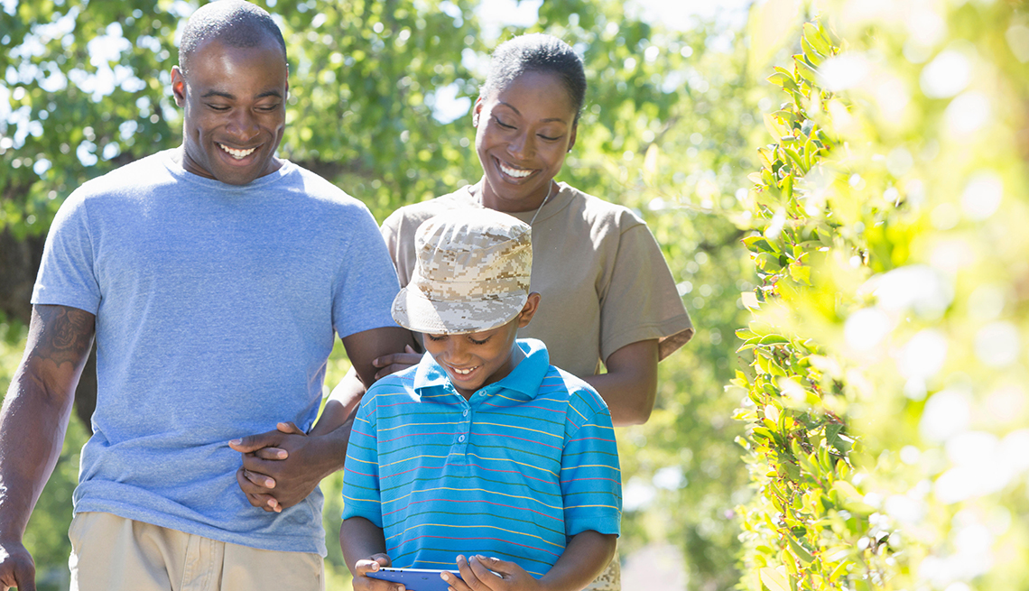 Madre y padre sonrientes caminan detrás de su hijo