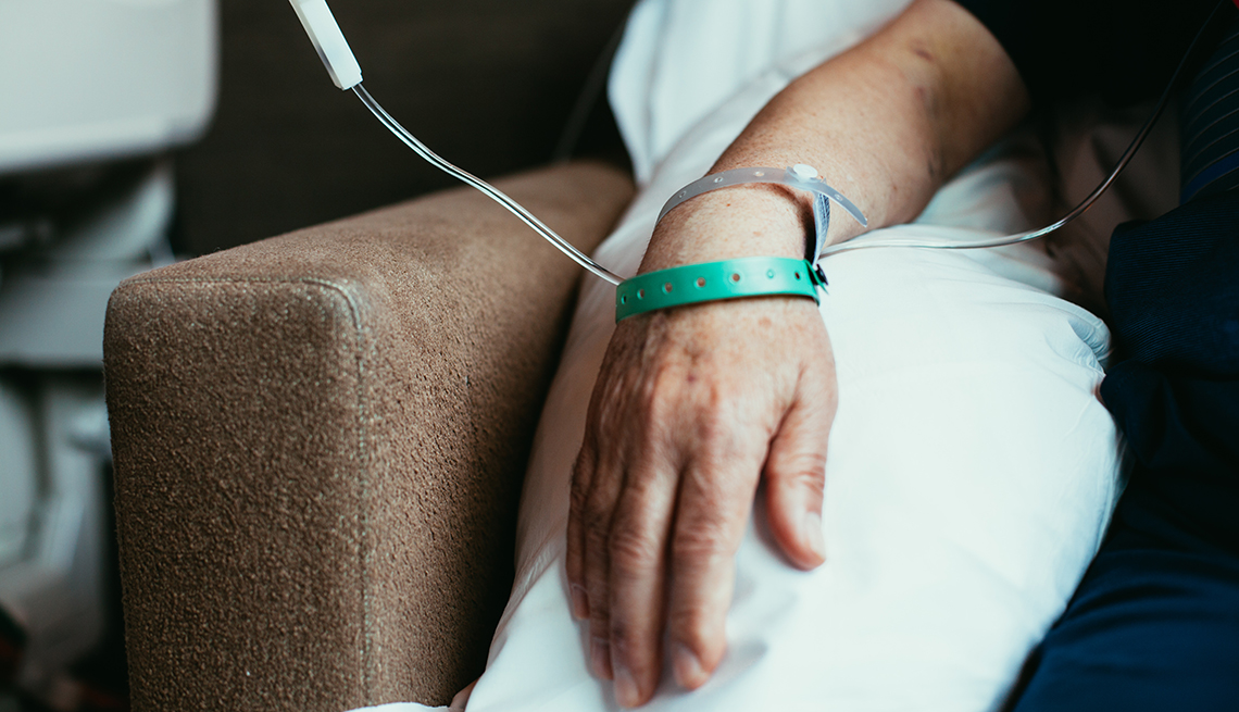 Mano de una persona sentada en una silla recibiendo tratamiento