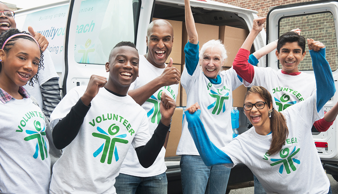 Un grupo entusiasta de voluntarios con los brazos arriba