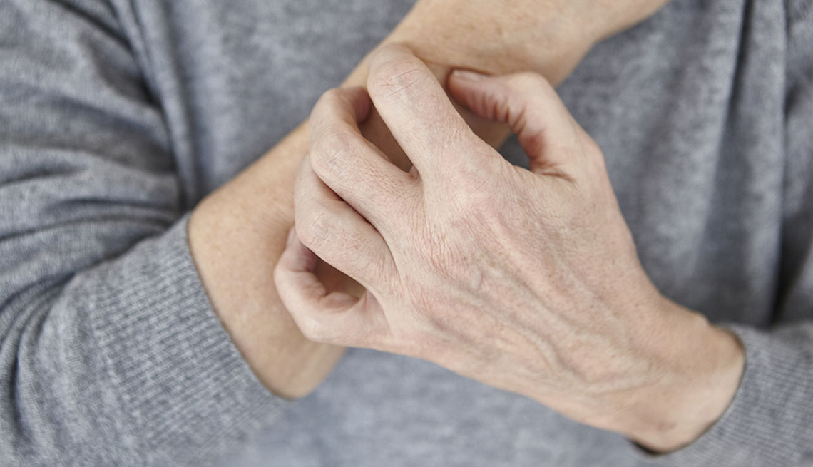 Una mujer se rasca el brazo