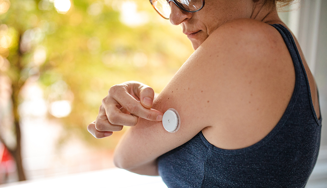 Una paciente de diabetes ajusta su monitor de glucosa