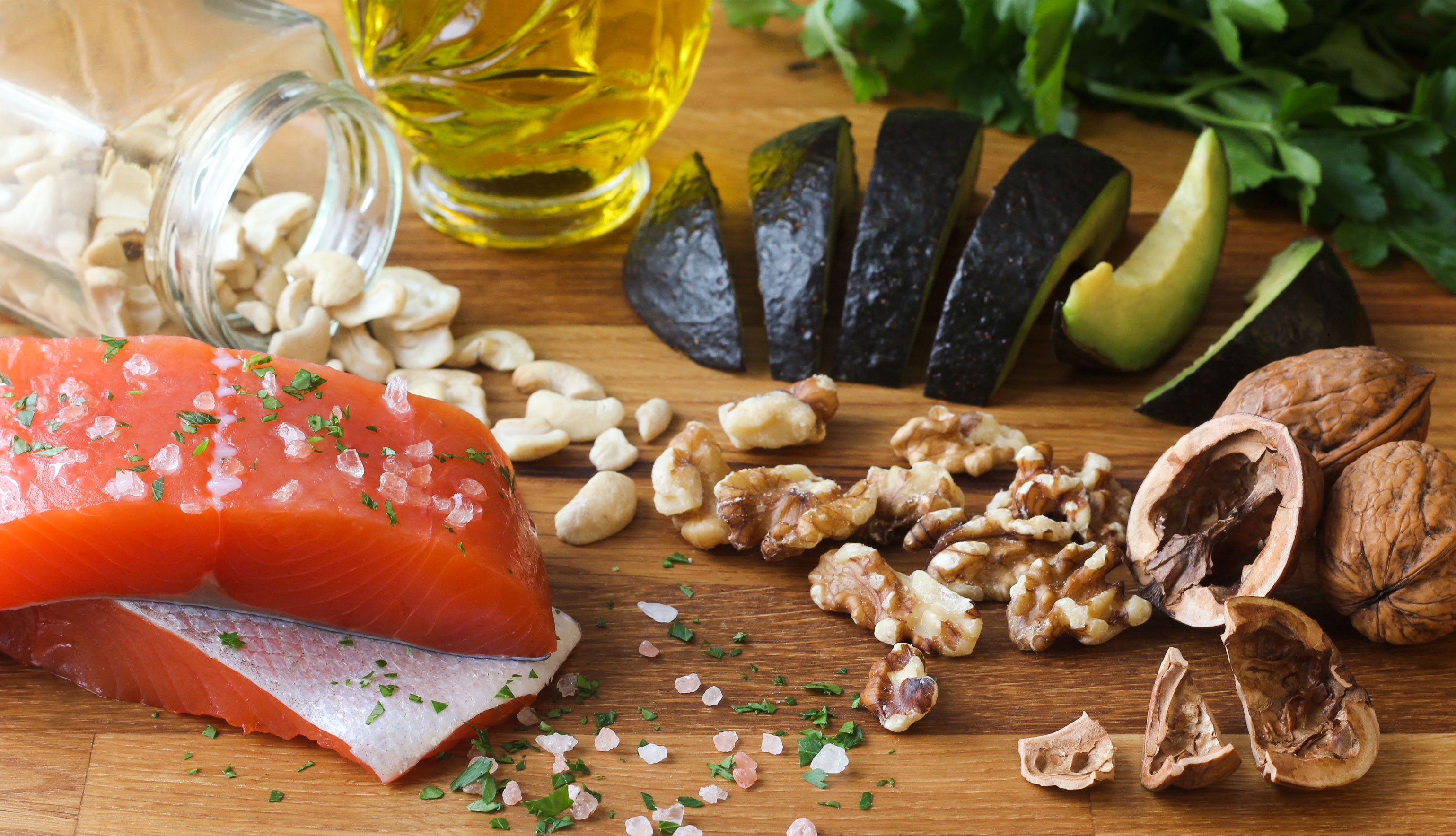 Salmón, nueces, aceite de oliva y aguacate sobre una mesa