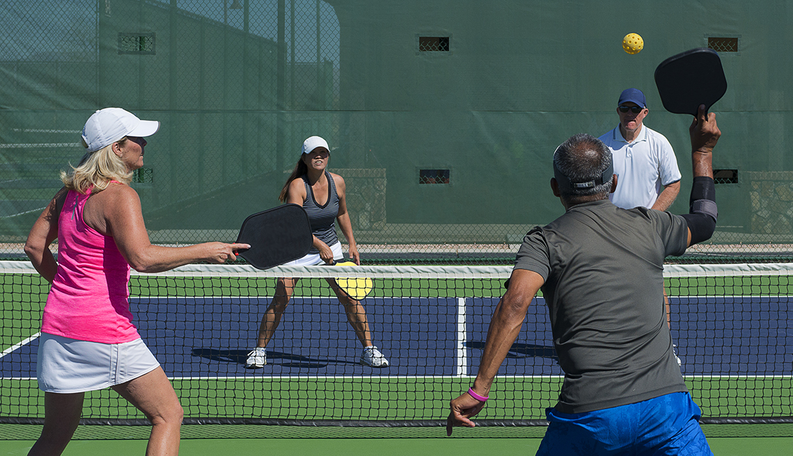 Dos parejas jugando pickleball Imagen de acción colorida de dos parejas jugando en la cancha