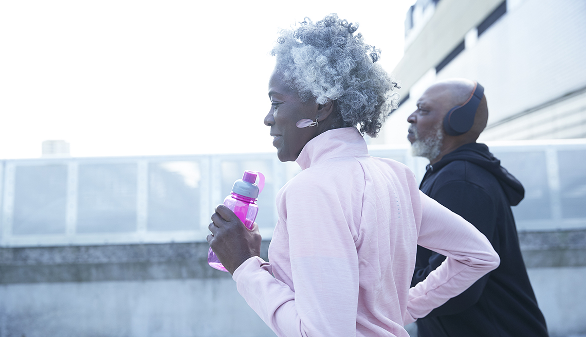 Una mujer y un hombre corren al aire libre