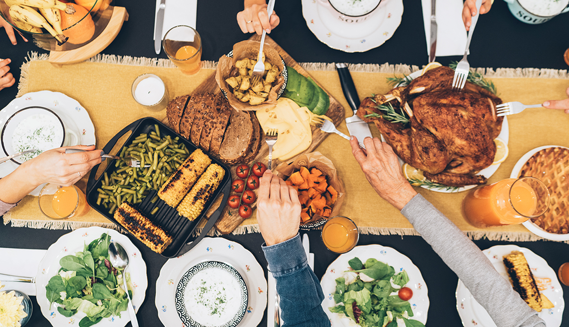 Personas se sirven comida en la mesa durante una cena