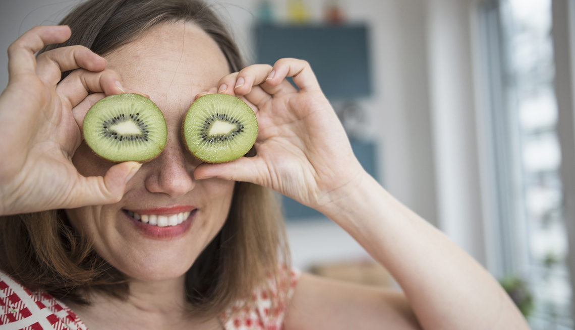 Una mujer se lleva unas rebanadas de kiwi a los ojos