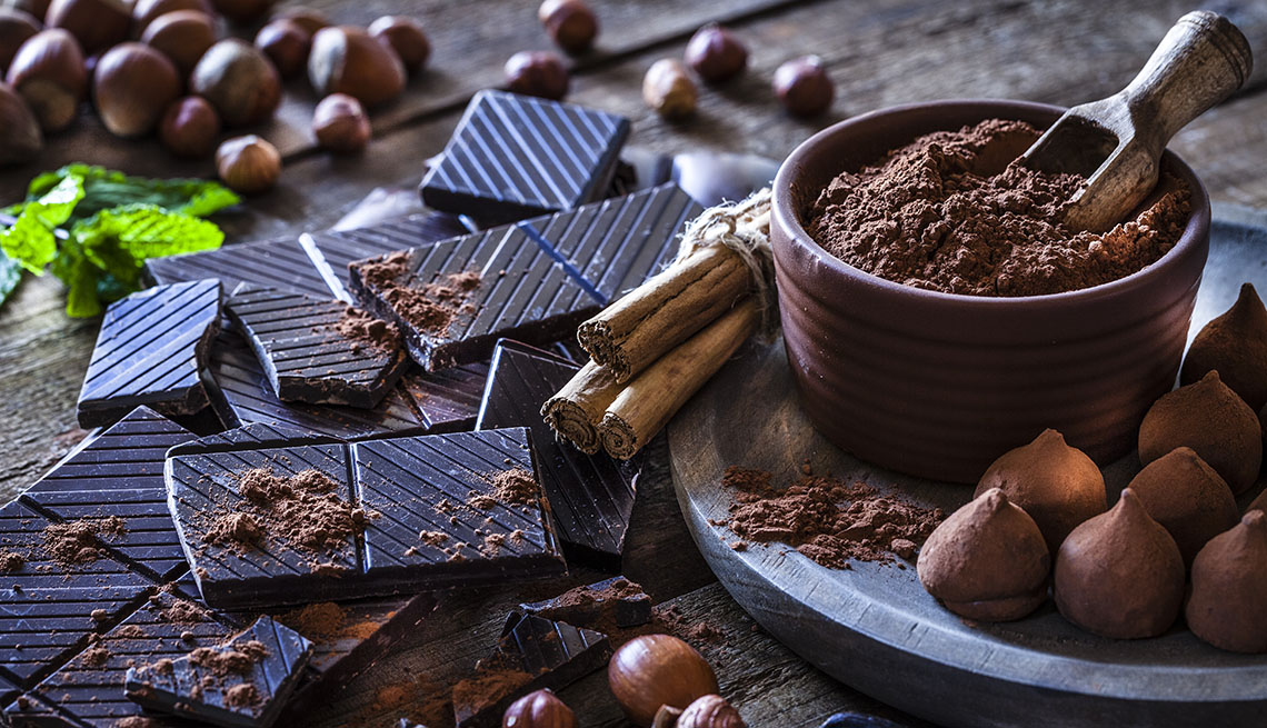 Mesa donde se ven trufas, barras de chocolate y cacao en polvo