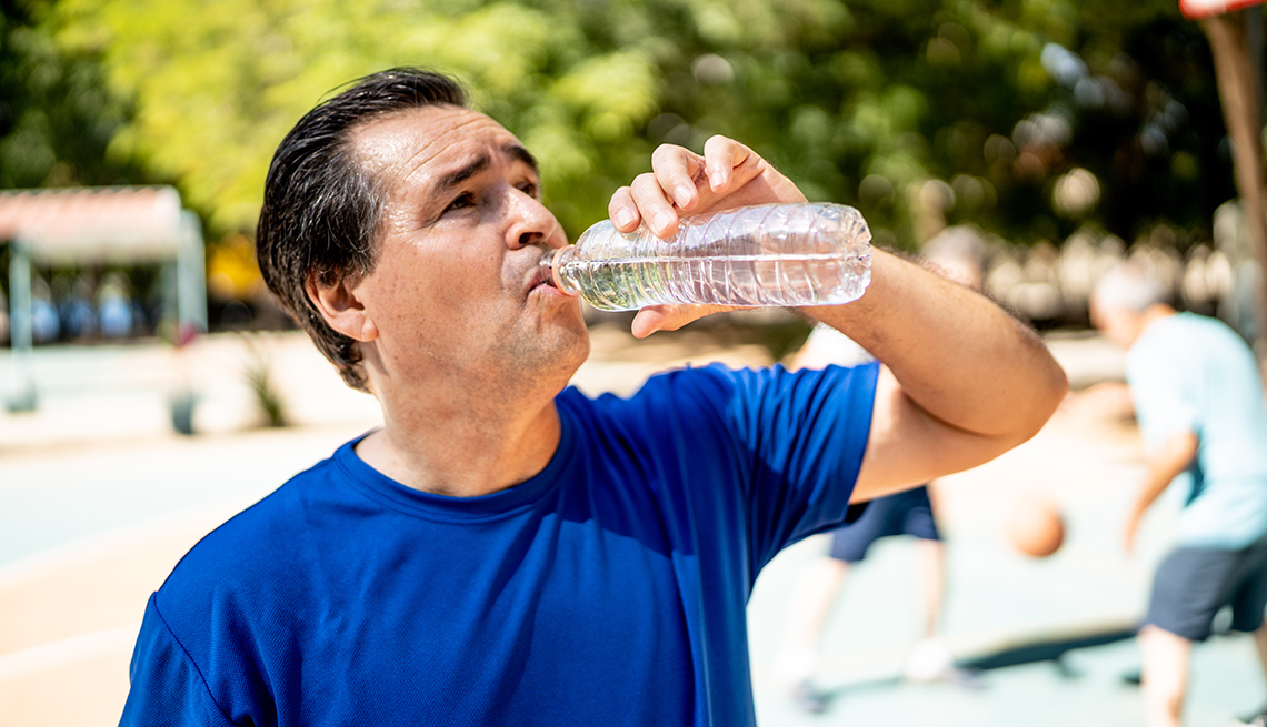 Un hombre toma agua de una botella