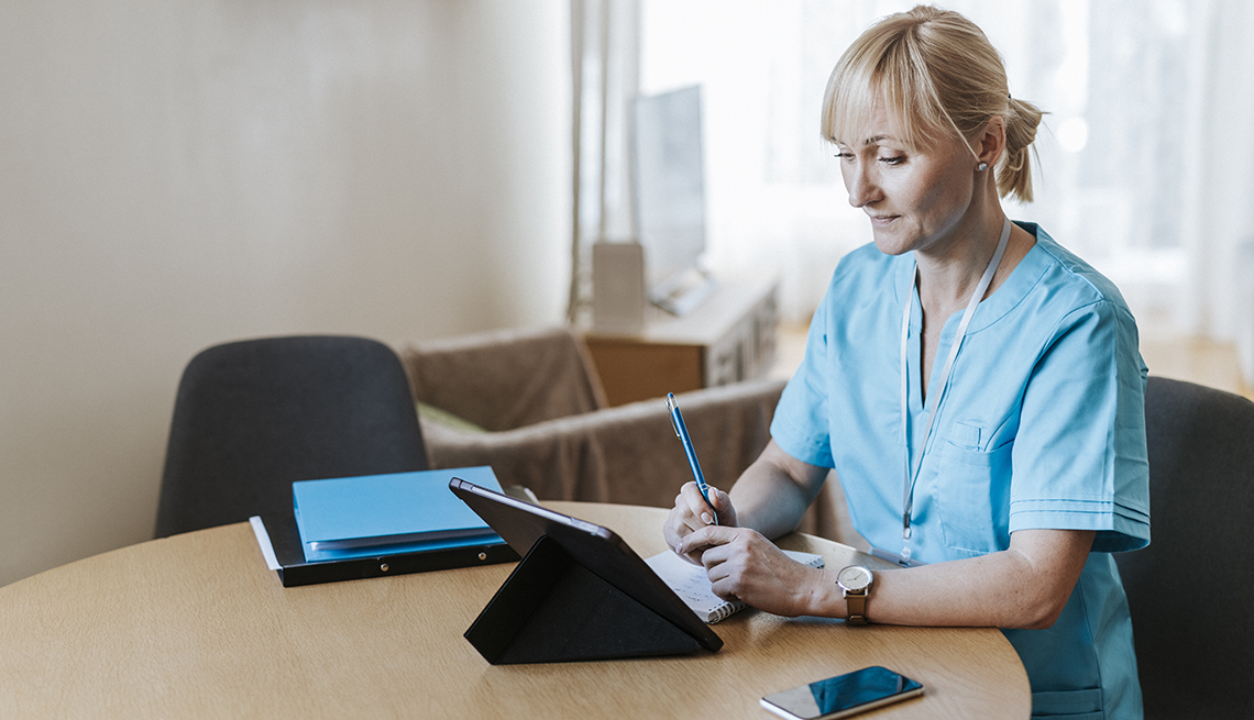 Enfermera mirando una tableta desde su casa.